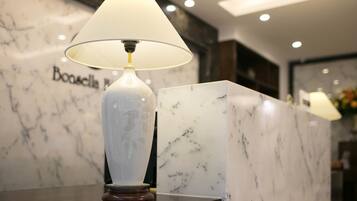 A marble reception desk with a lamp and a sign that reads "Boaselle."