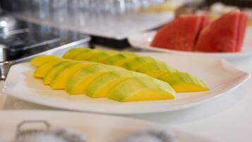 Un piatto con fette di mango e anguria su un tavolo.
