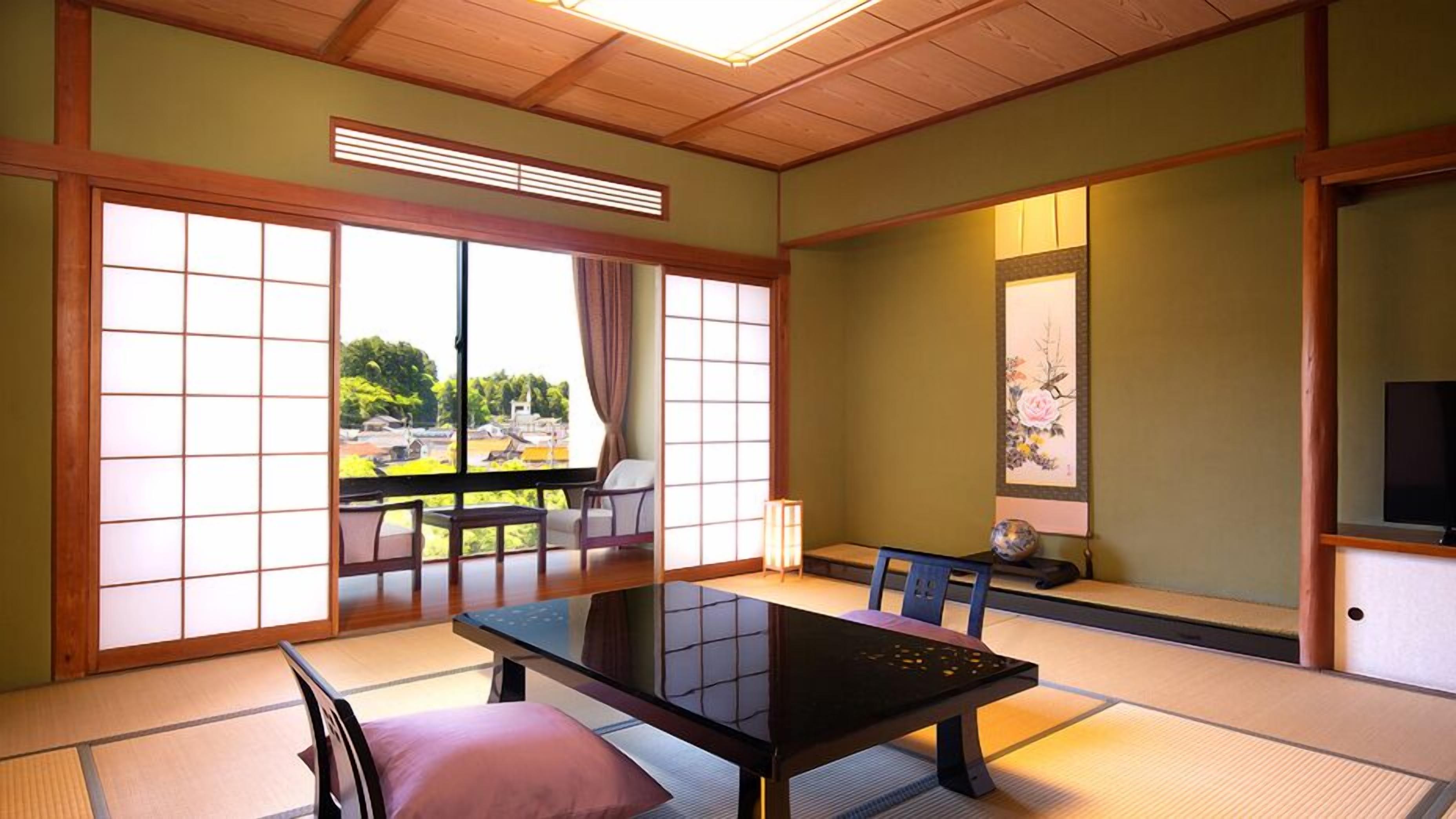 A traditional Japanese room with tatami flooring, a low table, a TV, and a sliding door leading to an outdoor area.