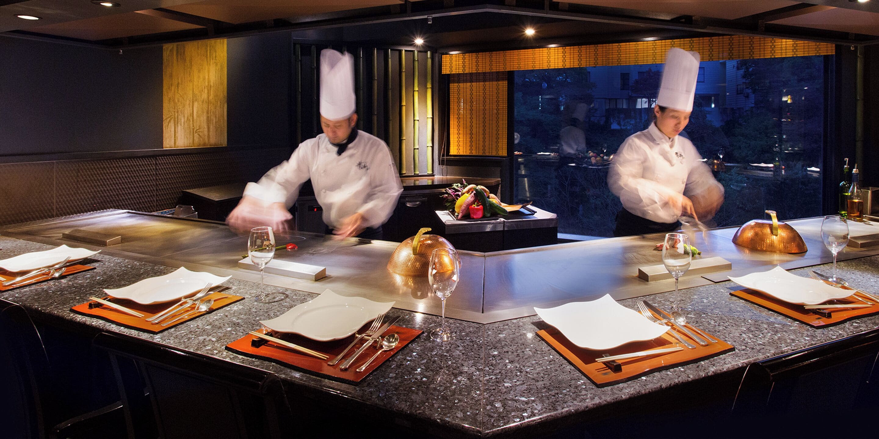 A modern kitchen with chefs preparing food.