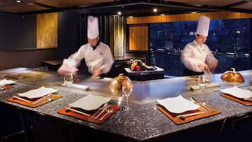 A modern kitchen with chefs preparing food.