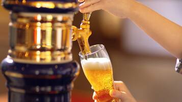 Uma mão servindo cerveja de uma torneira em um copo.