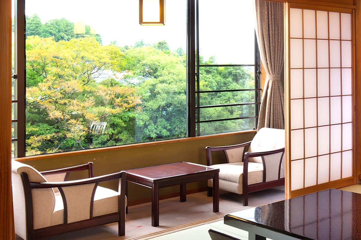 A traditional Japanese room with tatami flooring, a low table, and a sliding door.