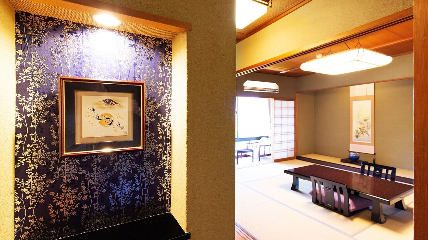A traditional Japanese room with tatami flooring, a low table, and a framed artwork on the wall.