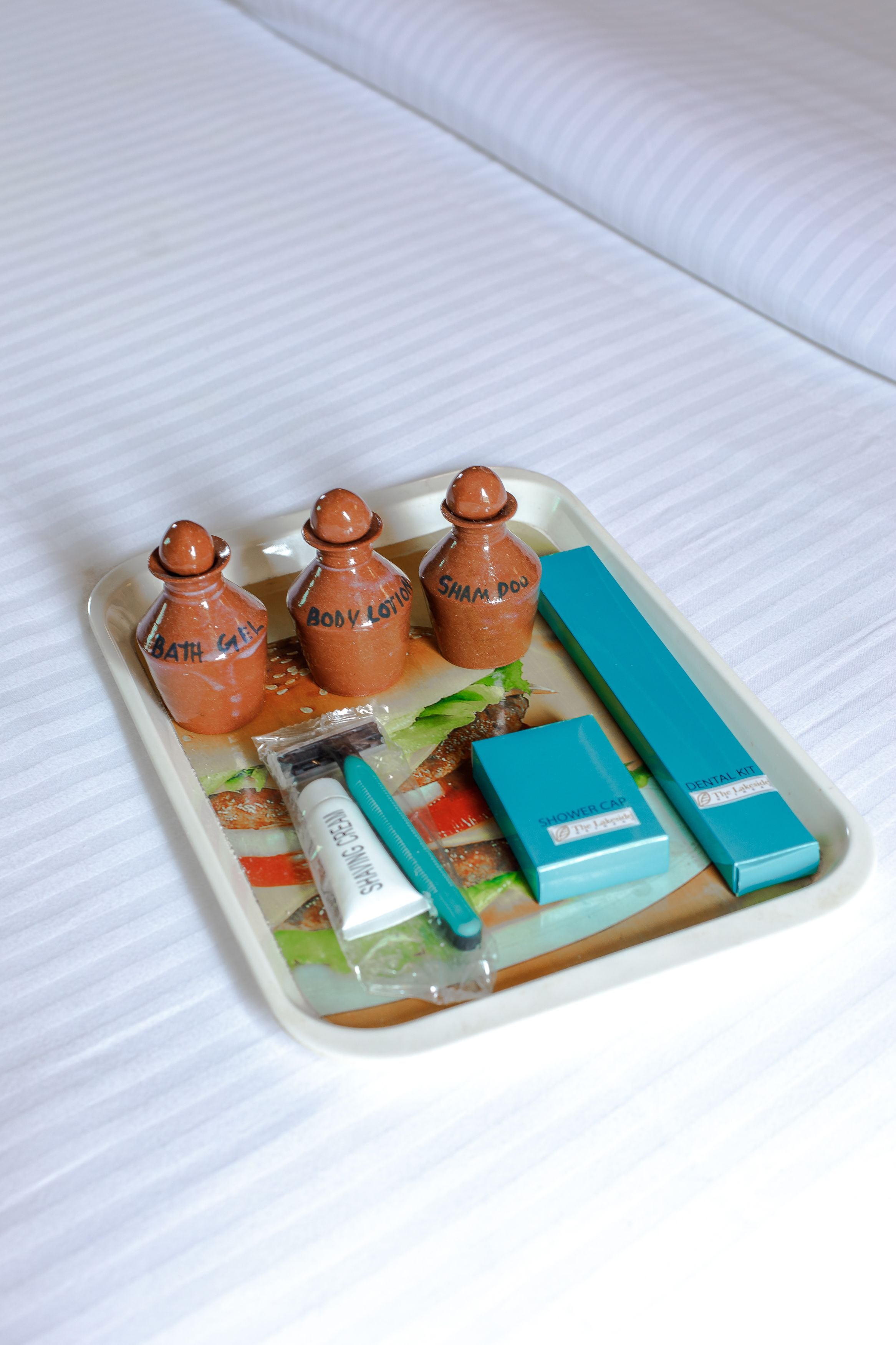 A tray with toiletries including body lotion, shampoo, and a razor.