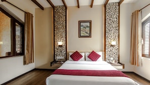 A hotel room with a large bed, wooden beams, stone wall panels, and a framed picture on the wall. - The Lakeside Retreat Pokhara by IME Hospitality (Pokhara)
