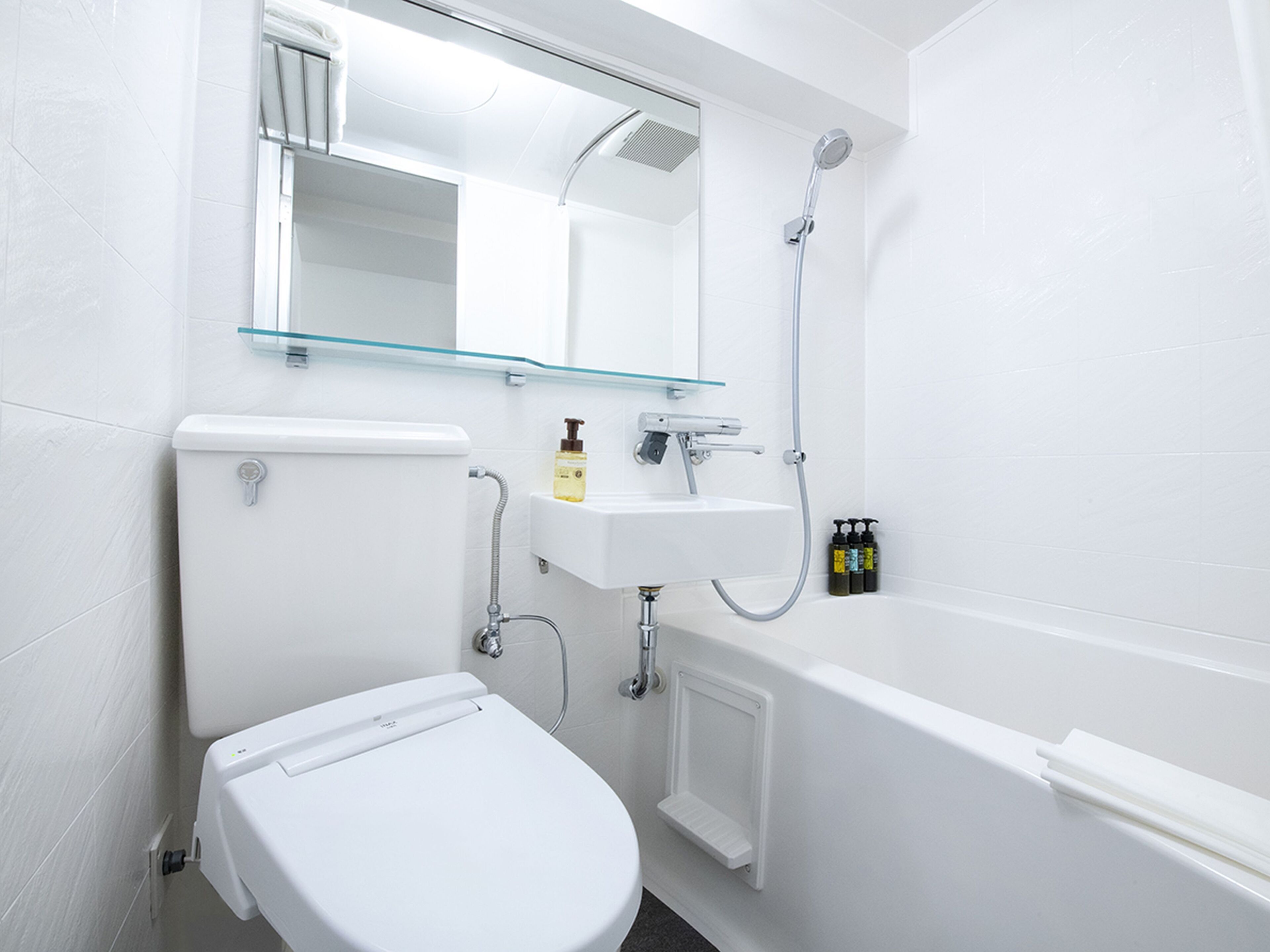 A modern bathroom with a toilet, sink, and shower.