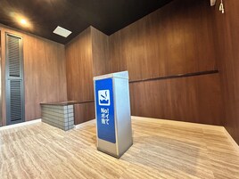 A no-smoking sign in a modern room with wooden walls and a tiled floor.