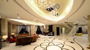 A spacious lobby with a grand chandelier, a reception desk, a staircase, and a red sofa. - Landmark Premier Hotel (Dubai)