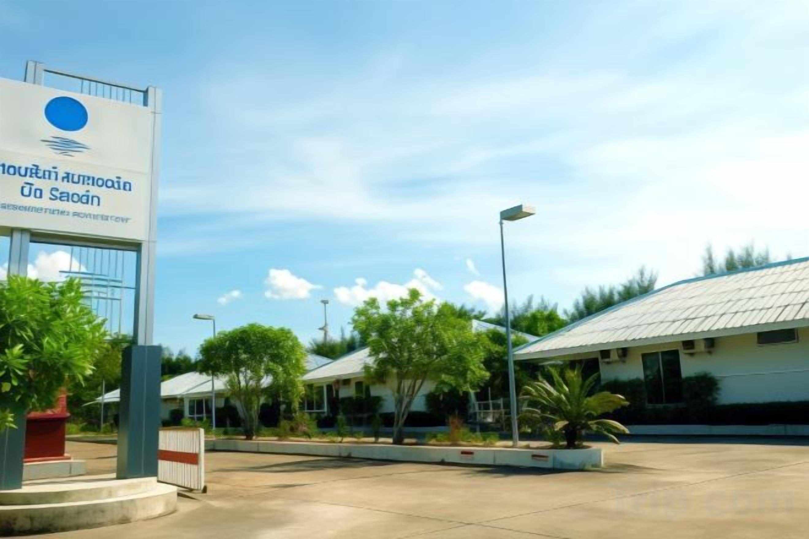 A building with a sign, a covered parking area, and a clear sky.