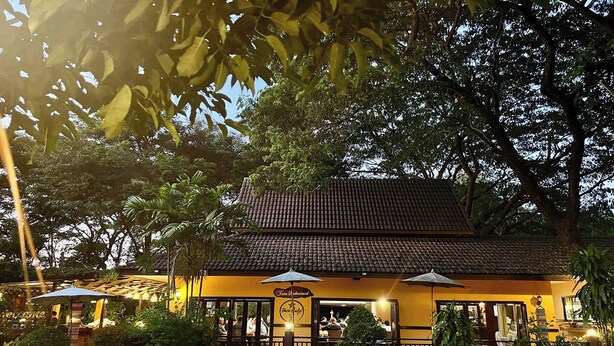 A restaurant with outdoor seating, a tiled roof, and a sign indicating it is a cafe. - Papai Country Lodge (Doi Saket)
