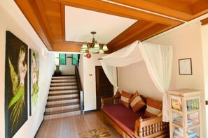 A room with a bed, a staircase, and artwork on the walls. - Papai Country Lodge (Doi Saket)