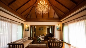A spacious room with wooden beams, a chandelier, and a sofa set. - Papai Country Lodge (Doi Saket)
