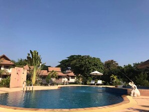 A swimming pool with lounge chairs and a lifeguard stand. - Papai Country Lodge (Doi Saket)