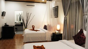 A hotel room with two beds, a bedside table with a lamp, a small desk with a computer, a mirror, and a decorative plant. - Golden Orchid Angkor (Siem Reap)
