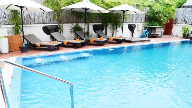 A swimming pool with lounge chairs and umbrellas. - Golden Orchid Angkor (Siem Reap)
