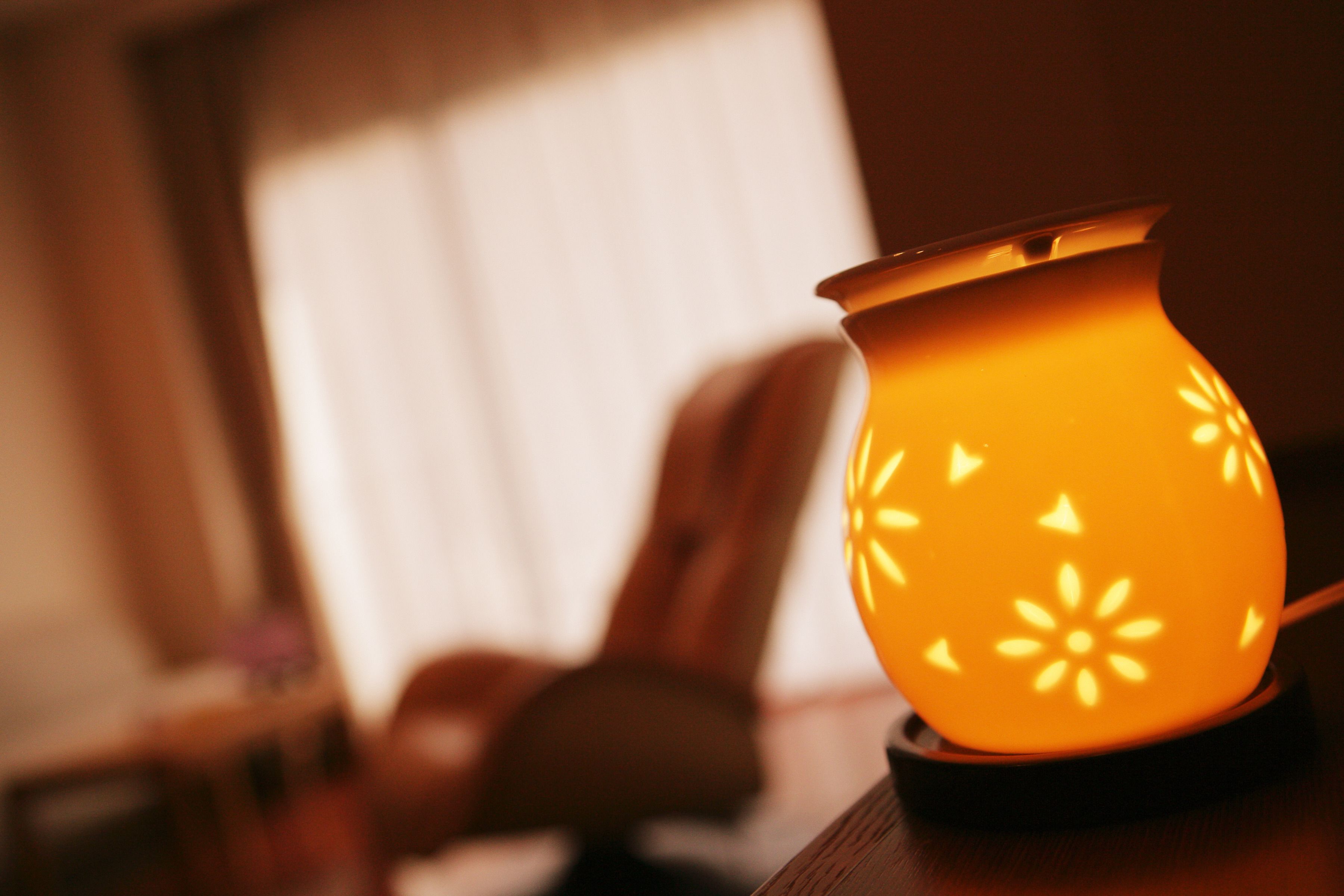 A lit candle holder on a wooden surface.