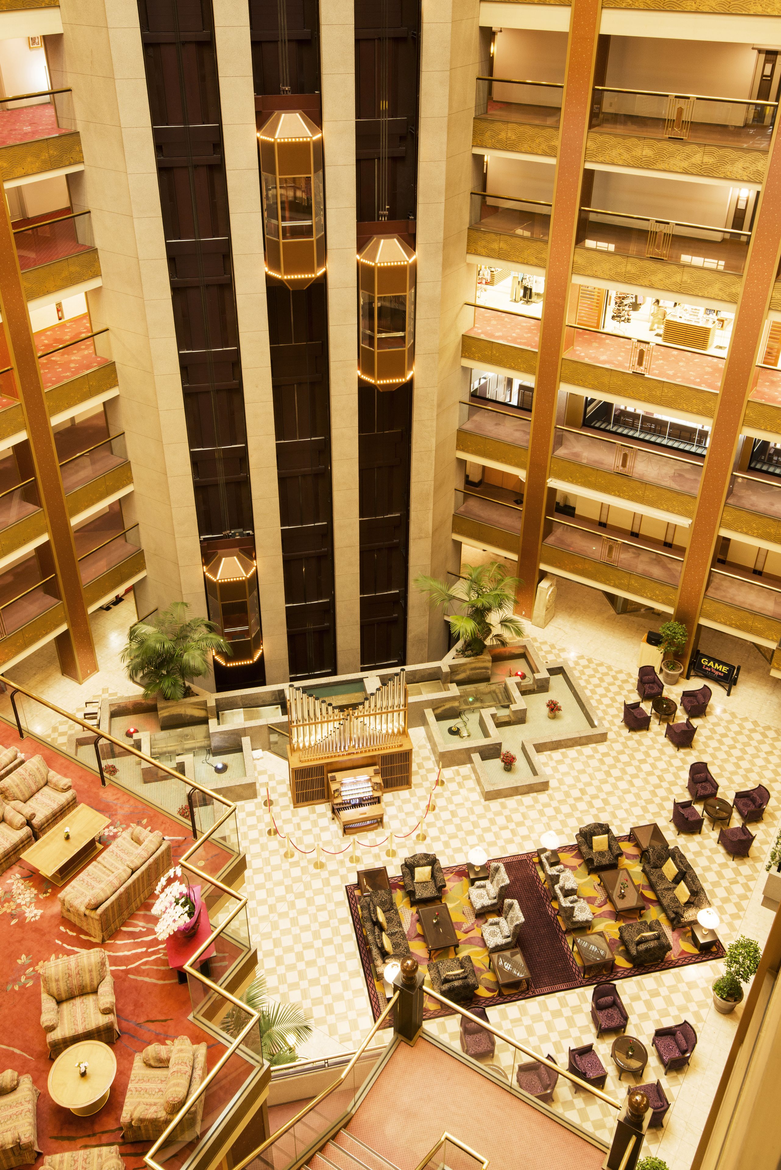 A multi-level hotel lobby with a central atrium, multiple floors, and a variety of seating areas.