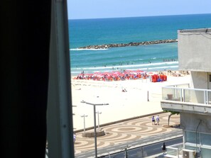 Una playa con sombrillas y gente.