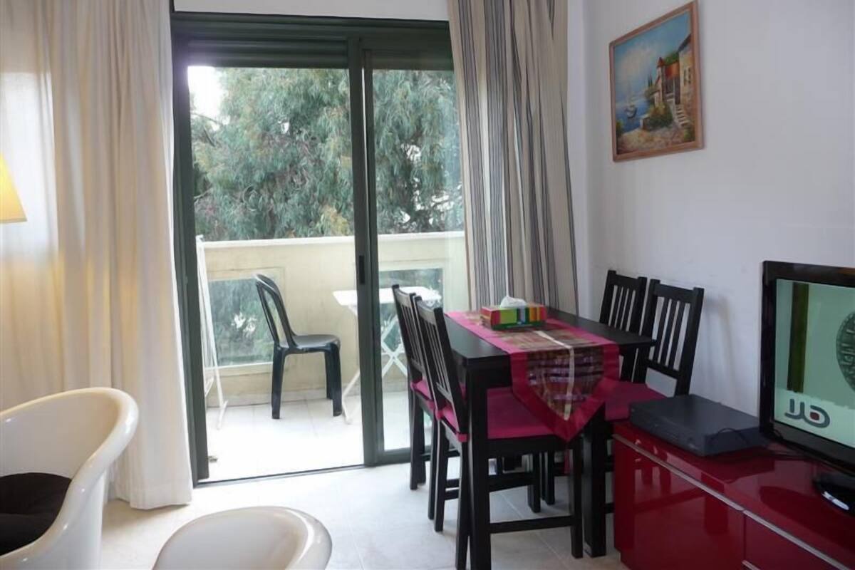 Un comedor con una mesa, sillas y un televisor.