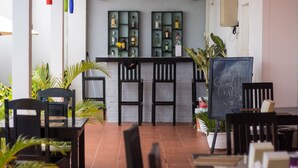A restaurant with a brick floor, black chairs, and a chalkboard with writing. - Overflow Guesthouse (Siem Reap)