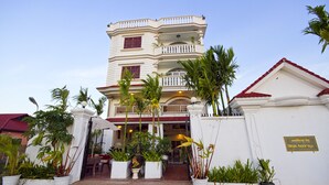 A multi-story building with a white facade, balconies, and a red roof. - Overflow Guesthouse (Siem Reap)