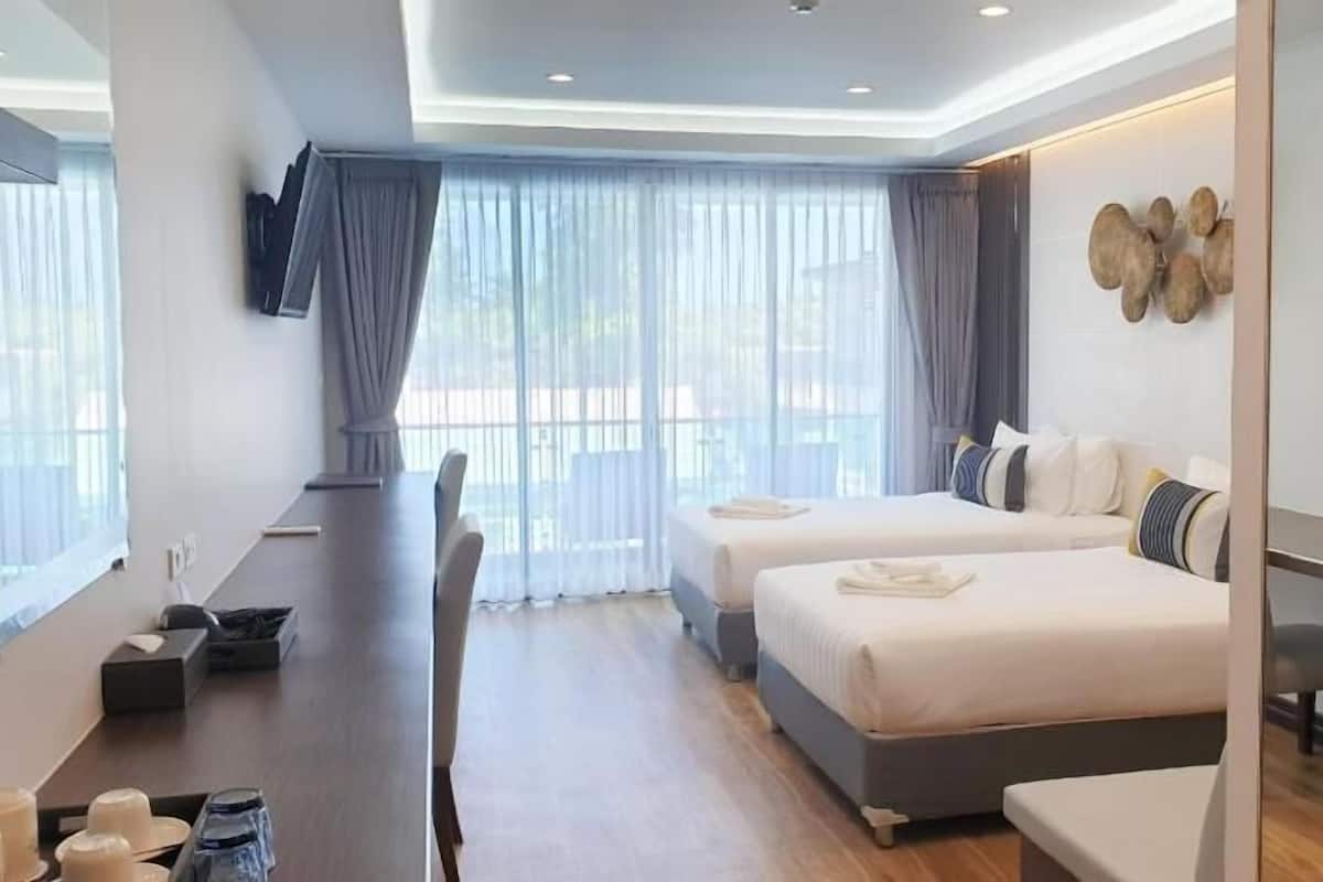 A modern hotel room with a bed, a desk, and a TV.