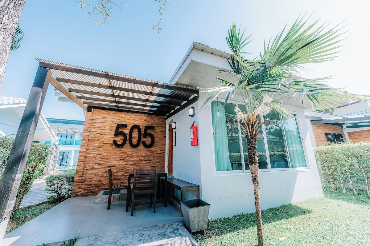 A modern building with the number 505 on its facade, a covered entrance, and a small outdoor seating area.