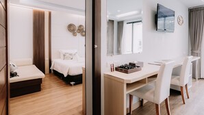 A modern hotel room with a bed, desk, and chairs, a TV, and a large window. - Chaolao Cabana Resort (Tha Mai)