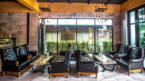 Ein gemütliches Restaurant mit Ledersofas, Holztischen und hängenden Lampen.