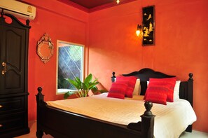 Quarto com cama, janela, planta e ar-condicionado fixado na parede.