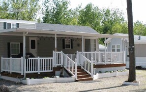 Stroll up to this charming two-story home with a covered porch and staircase leading to the upper level.