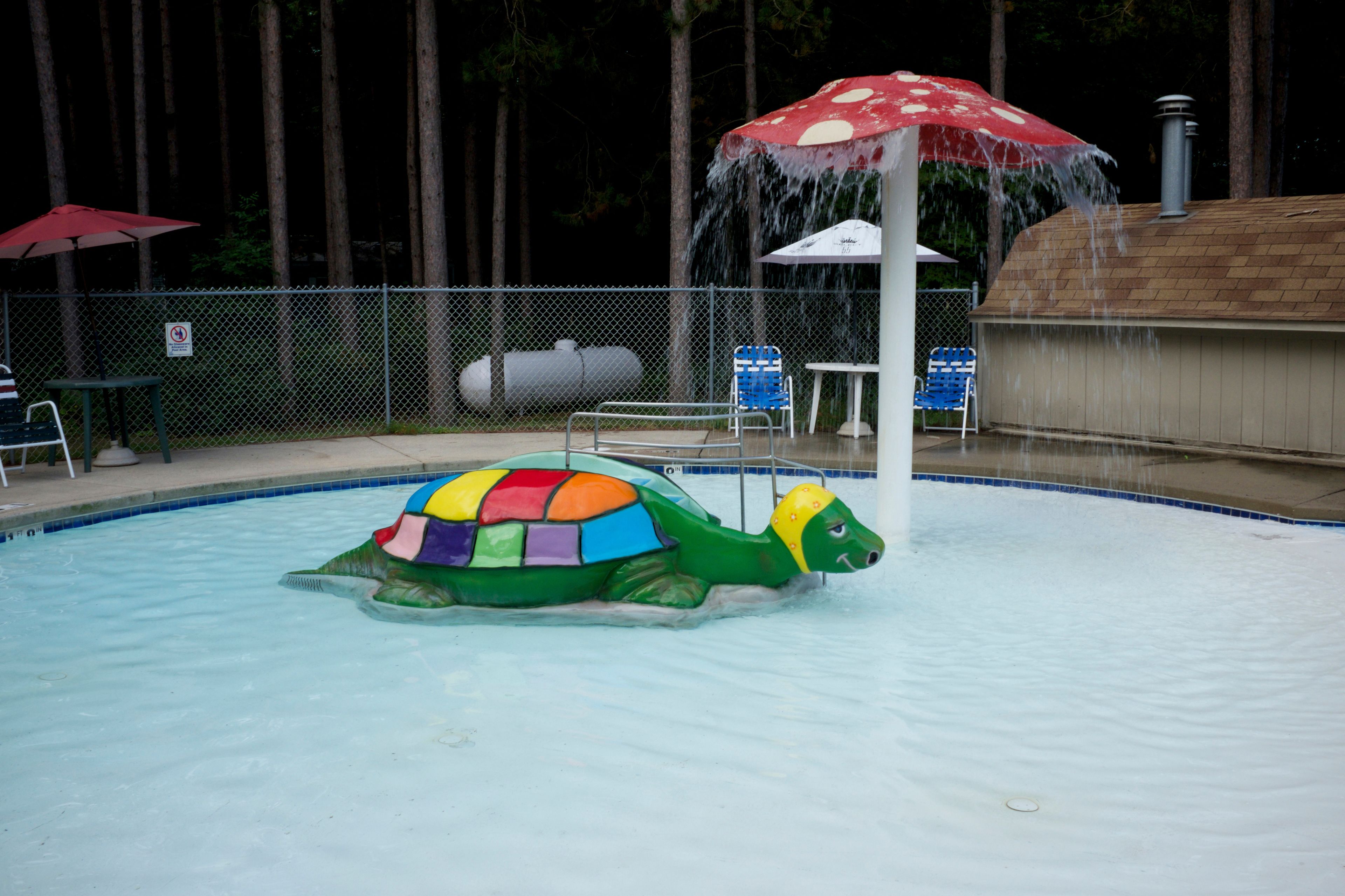 Una piscina al aire libre de temporada, sillones reclinables de piscina