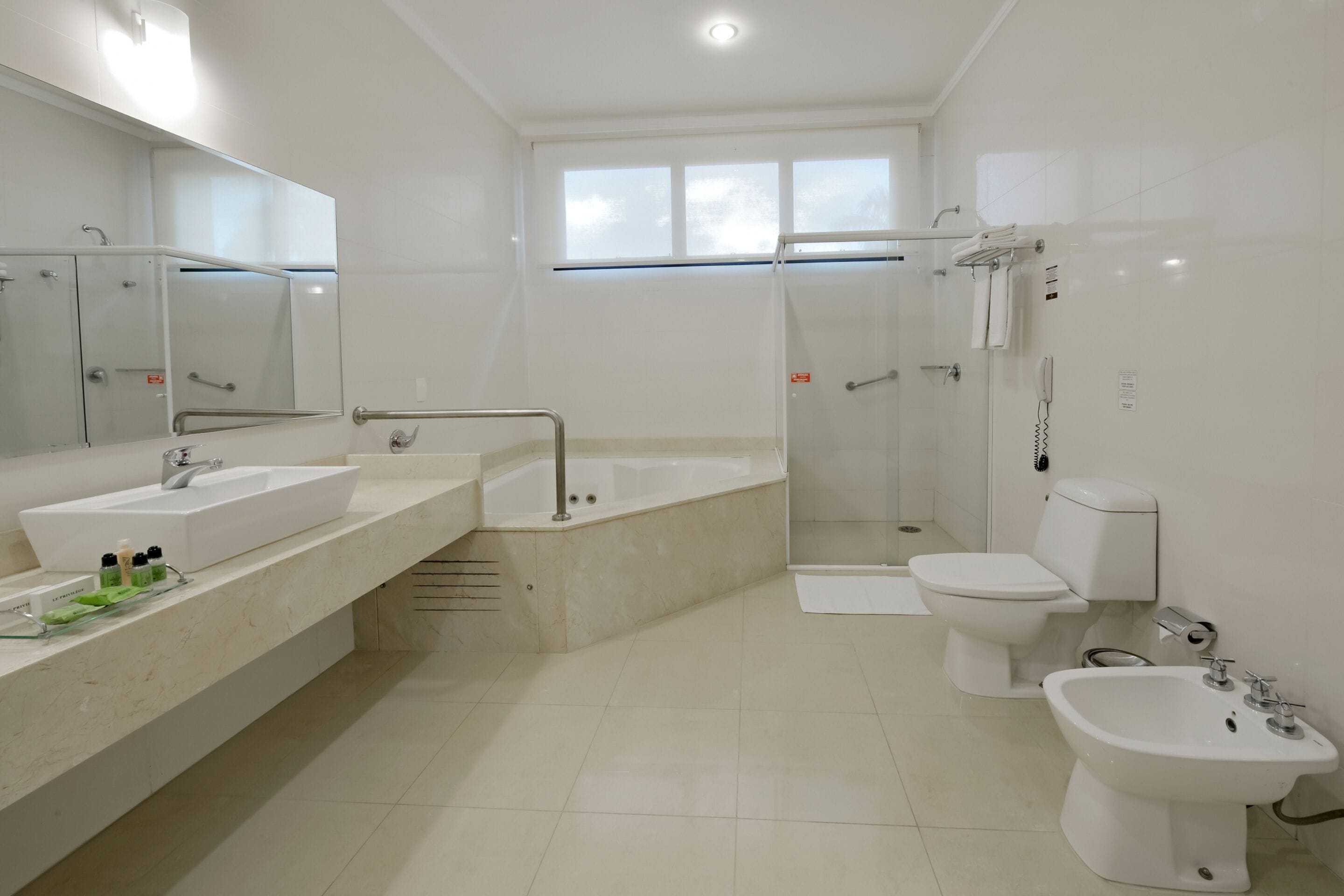 Ein modernes Badezimmer mit einer großen Badewanne, einer separaten Duschkabine, einer Toilette und einem Bidet.