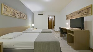 A hotel room with two beds, a desk, a chair, and a television. - Garden Hotel (Ribeirão Preto)