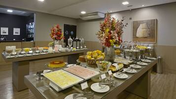Una mesa de buffet con diversos alimentos y un jarrón decorativo.