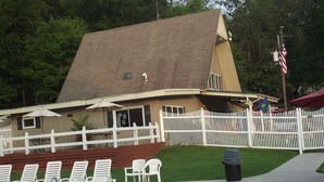 A pool area with lounge chairs and a white fence. - Sun Valley Camping and RV Resort (Narvon)
