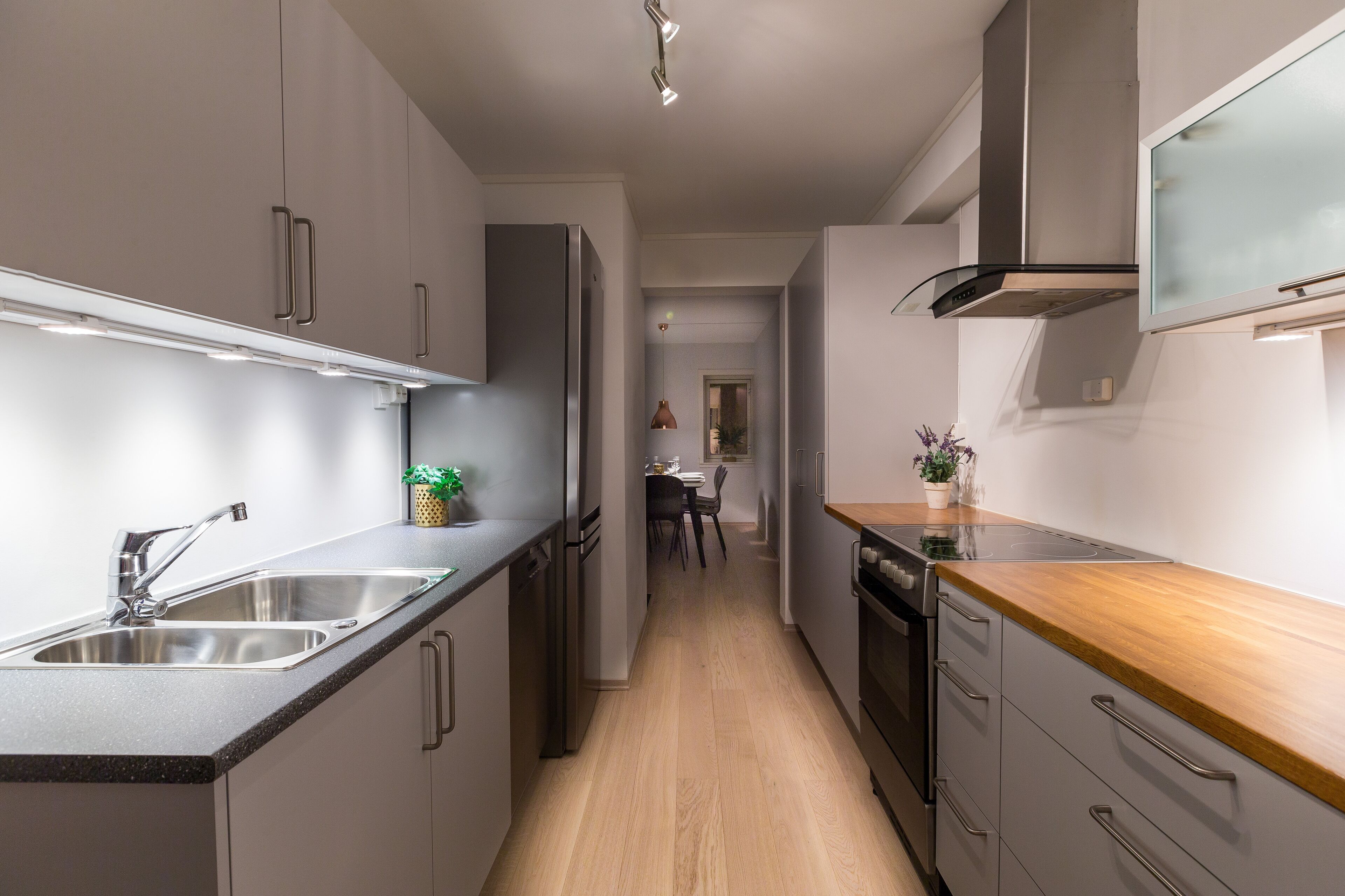 Una cocina moderna con electrodomésticos de acero inoxidable, encimera de madera y una isla central.