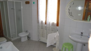 A bathroom with a shower, toilet, sink, and bathtub.