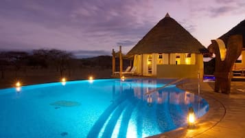 Una piscina al aire libre, sillones reclinables de piscina