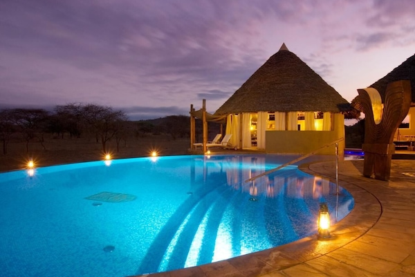 Una piscina al aire libre, tumbonas