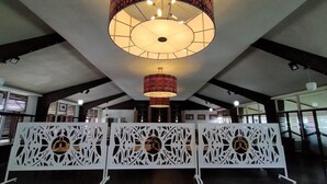 A spacious room with a high ceiling, a large circular chandelier, and a white decorative partition with circular cutouts. - Asana Biak Papua (Biak)