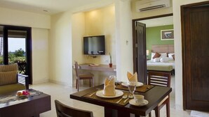 A hotel room with a dining area, a TV, a bed, and a view of the outdoors. - Asana Biak Papua (Biak)