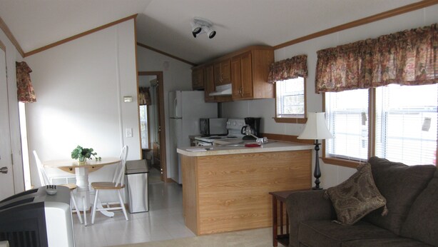 A compact living space with a kitchenette, a dining area, and a seating area.