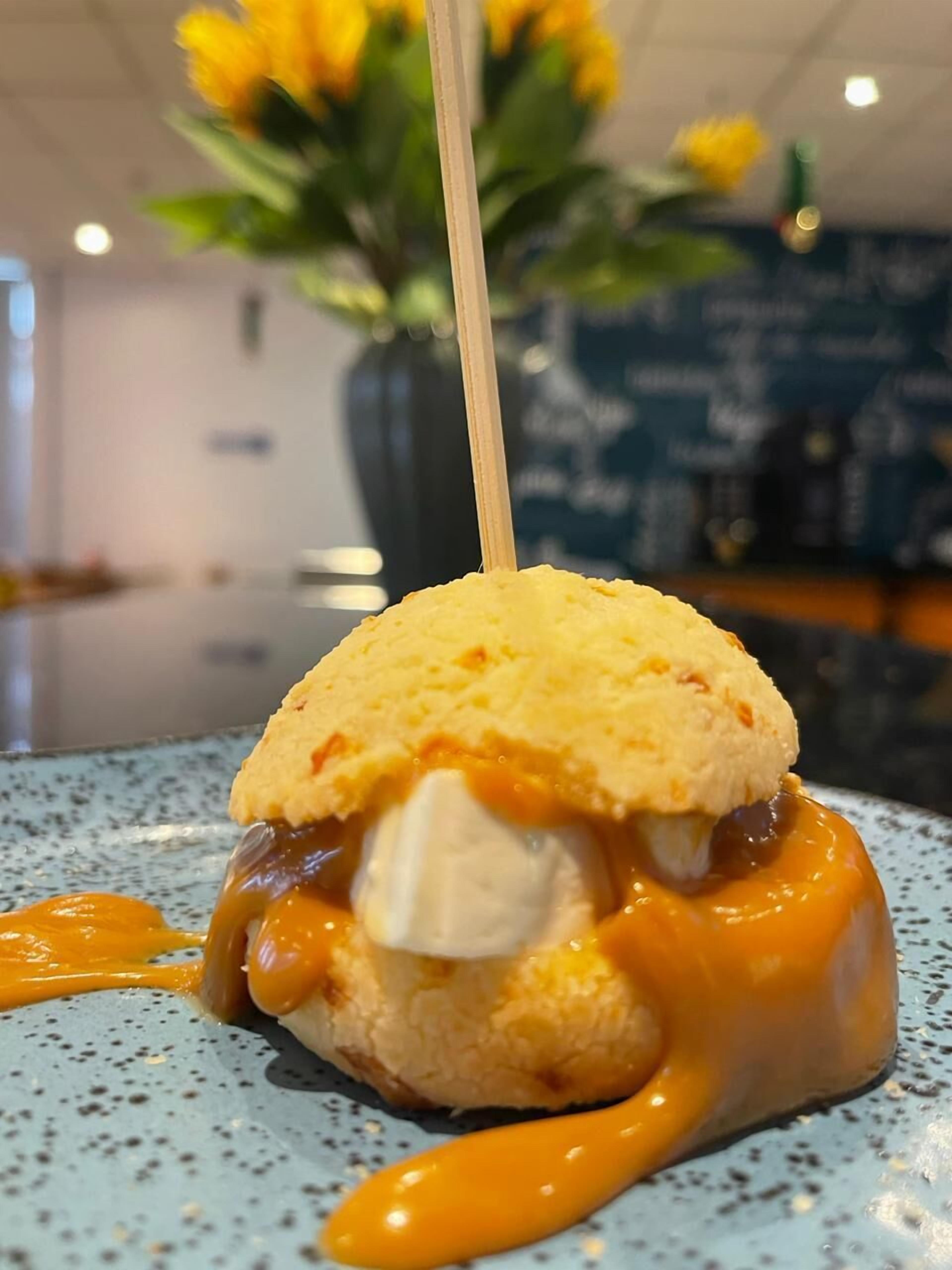 A dessert with a biscuit and caramel sauce on a speckled plate.