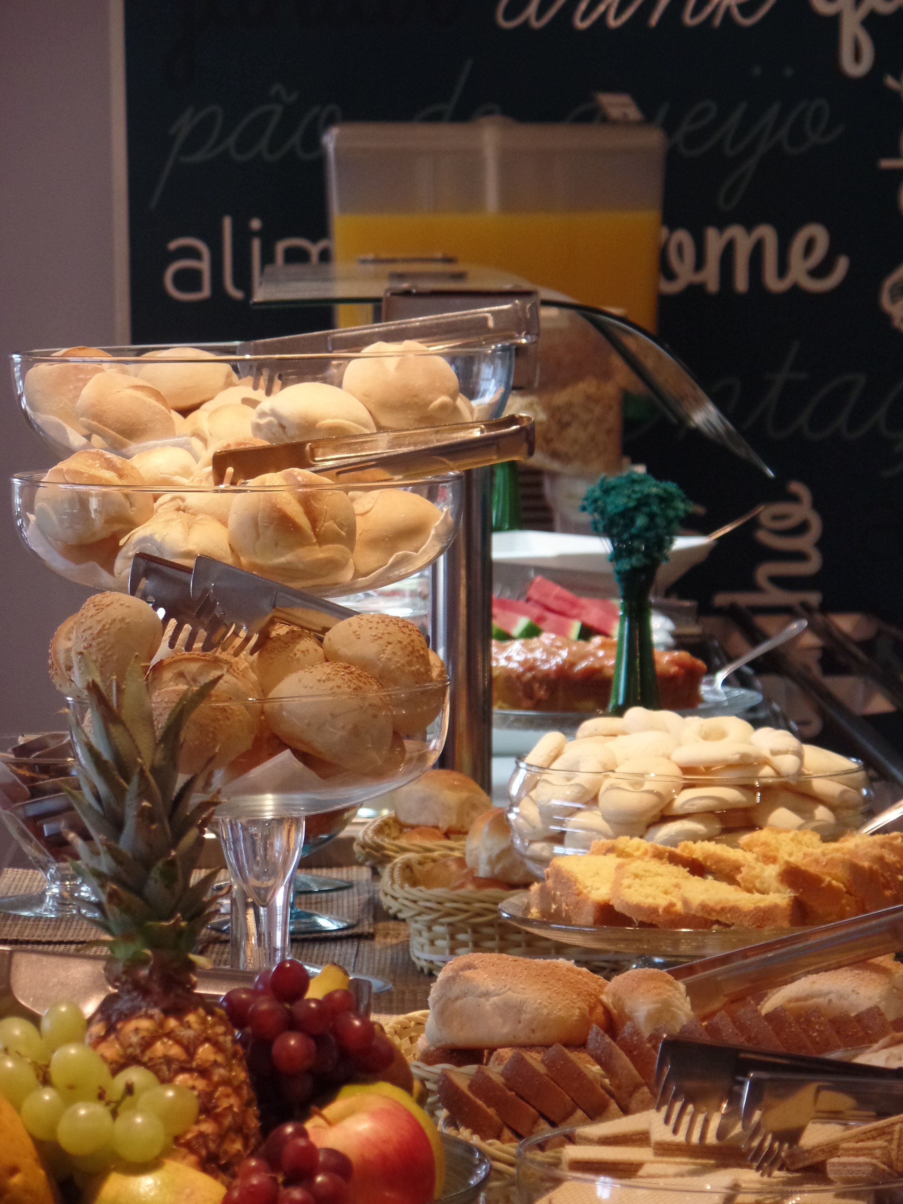 A buffet with various food items including bread, pastries, and fruits.