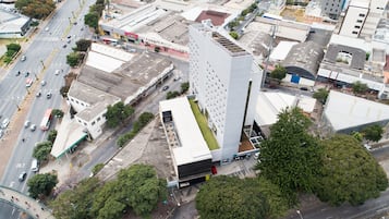 Vista aérea de un edificio moderno con techo plano, rodeado de calles y otros edificios.