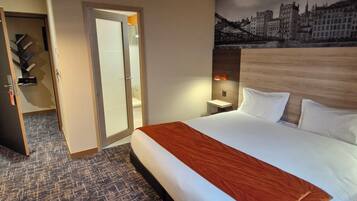 Una habitación de hotel con una cama grande, un mural con vista a la ciudad, un cabecero de madera y piso alfombrado.
