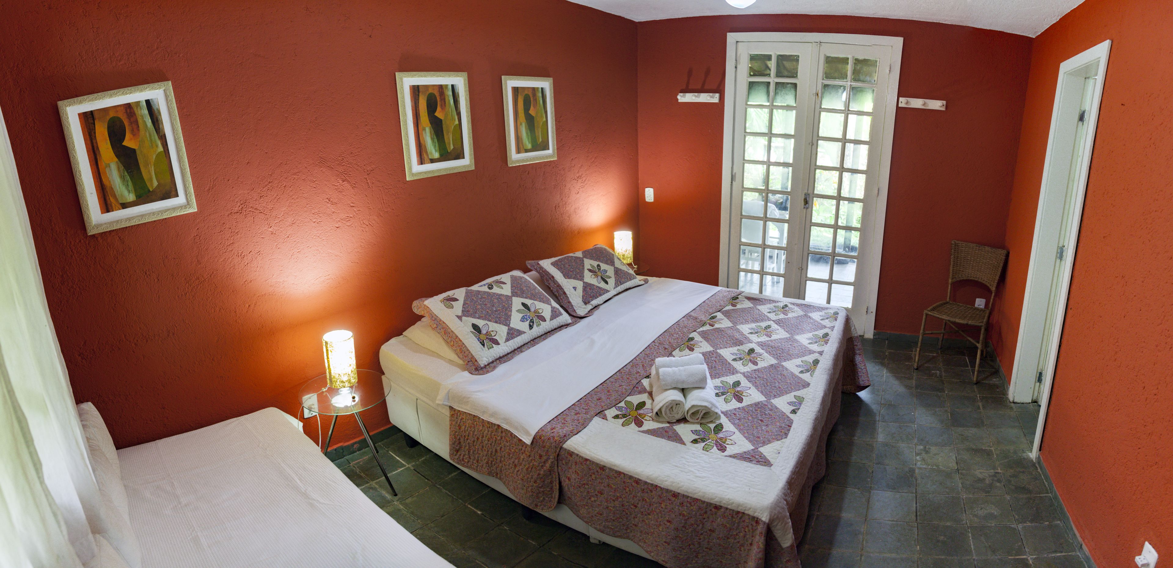 A bedroom with a bed, a chair, and a door.