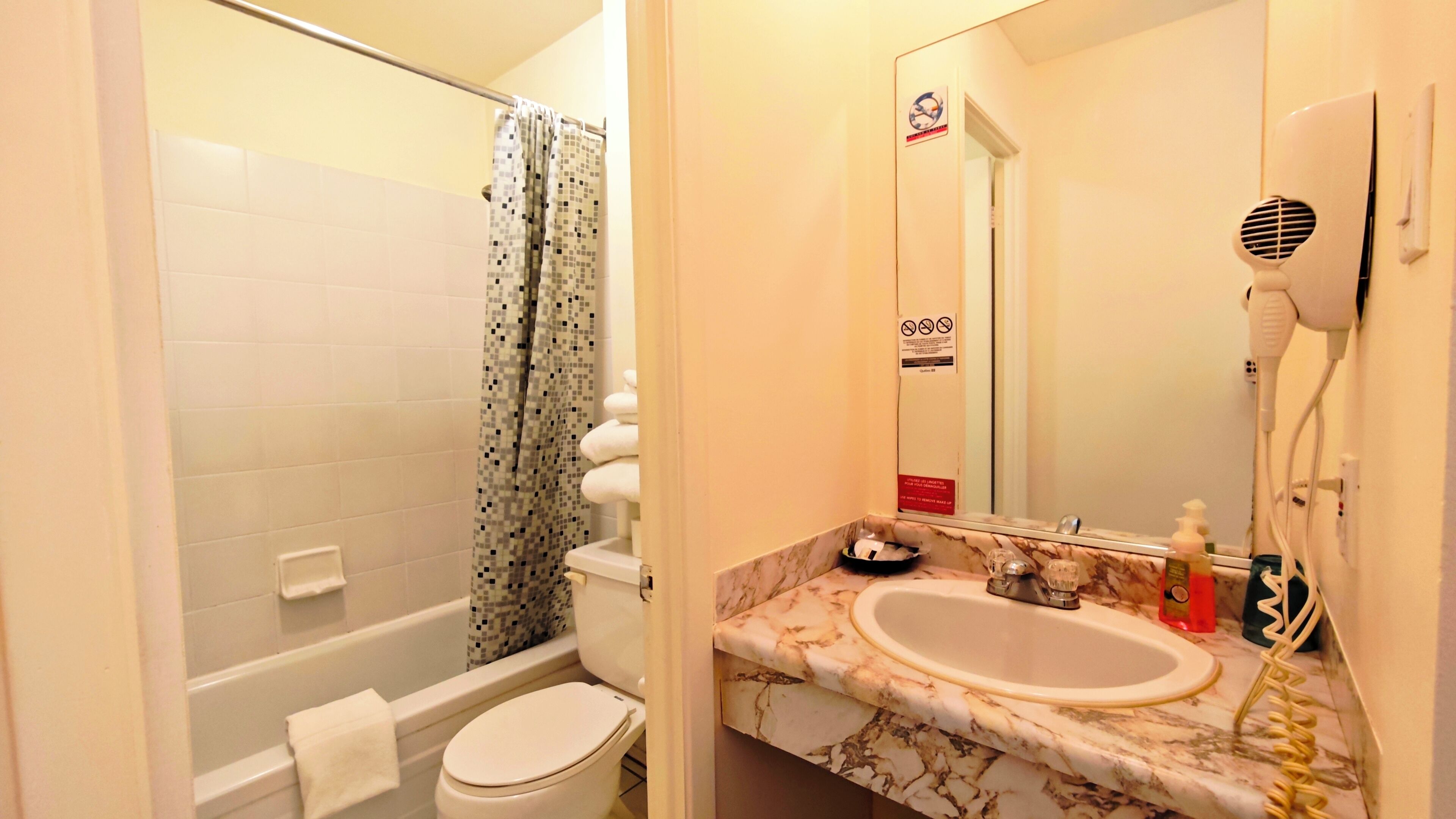A bathroom with a toilet, sink, and shower.